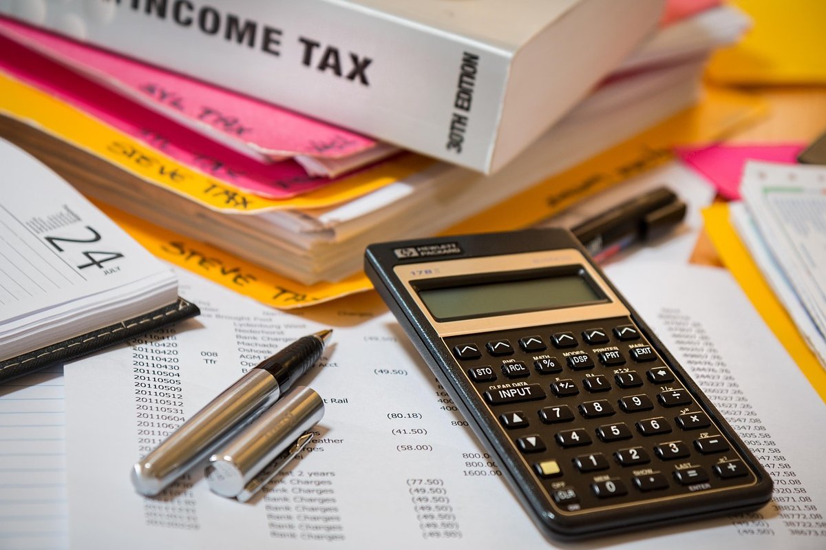 Calculadora financiera, libros de impuestos y documentos con cifras