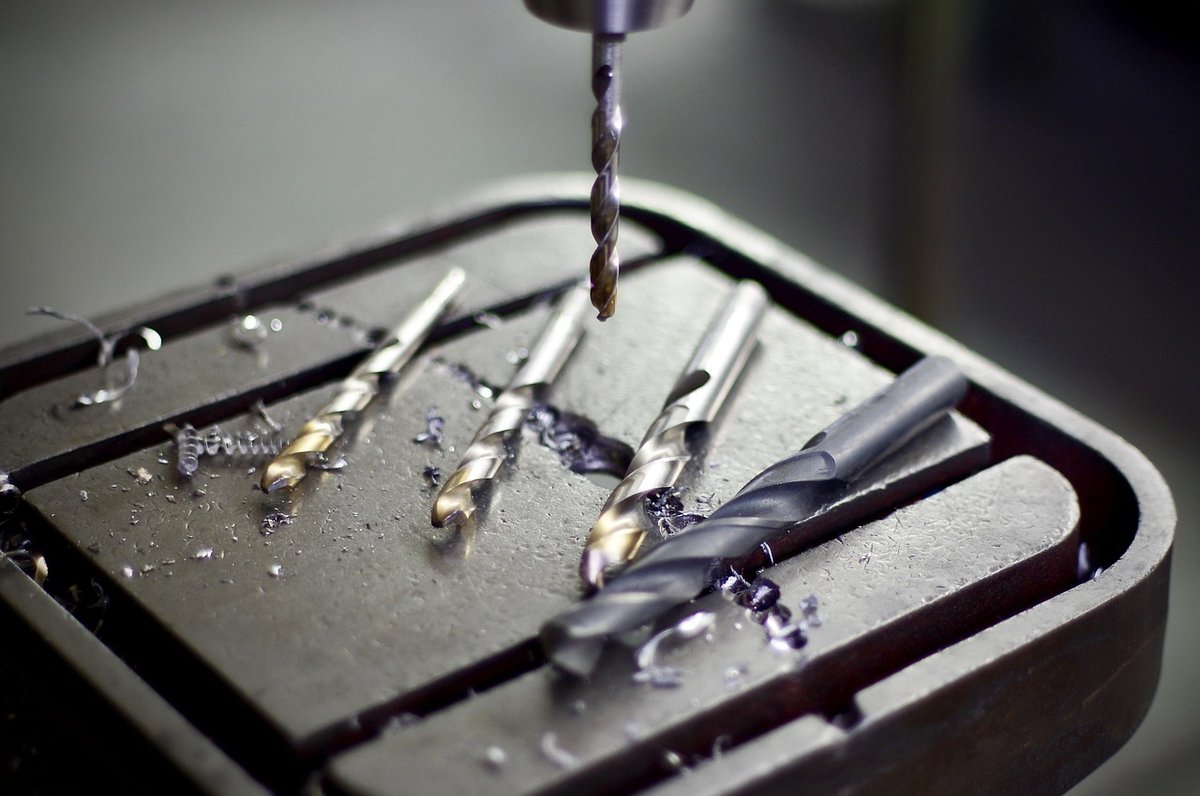 Brocas de acero y virutas metálicas en taller industrial, símbolo de
